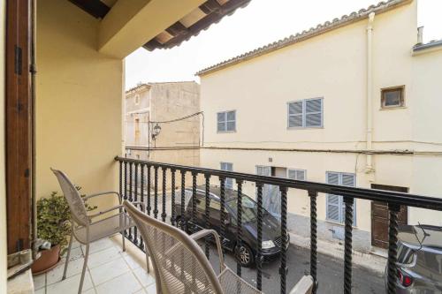 a balcony with chairs and a car parked on a street at Can Cosset Holiday Home in Capdepera