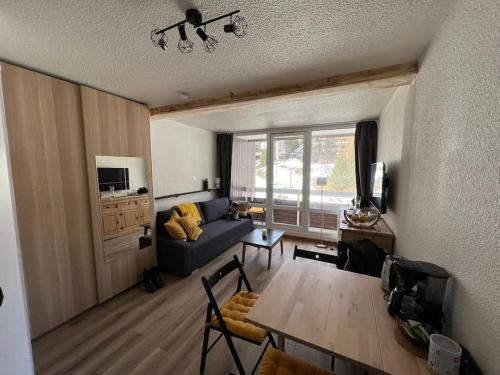 a living room with a blue couch and a table at Appartement Alpe-d'Huez 4 Personnes in L'Alpe-d'Huez