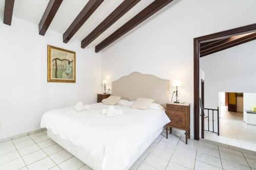 a bedroom with a large white bed in a room at Can Cosset Holiday Home in Capdepera