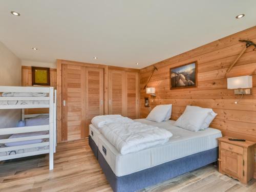 une chambre avec un lit et un mur en bois dans l'établissement Appartement 1 Chambre pour 4 à 6 Pers, Proche Centre et Pistes, Parking Inclus - FR-1-685-63, aux Gets