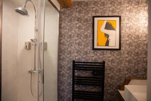 uma casa de banho com chuveiro e uma imagem na parede em Un petit bout du monde em Saint-Georges-en-Couzan
