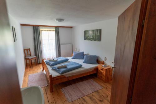 ein Schlafzimmer mit einem Bett mit blauen Kissen darauf in der Unterkunft Ferienwohnung Bauernhof Obererlach in Bramberg am Wildkogel
