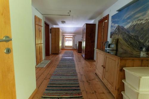 a hallway with a room with a mountain painting on the wall at Ferienwohnung Bauernhof Obererlach in Bramberg am Wildkogel