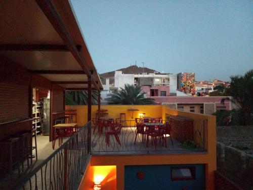 a patio with tables and chairs on a balcony at Orietta Residencial in Mindelo
