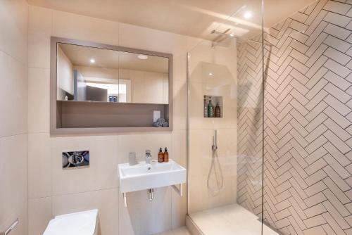 a bathroom with a sink and a shower with a mirror at York Central No 1, within the city walls, free parking in York