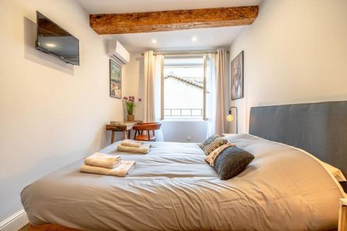 um quarto com uma cama grande com almofadas em Superbe appartement neuf, climatisé centre village em Plan-de-la-Tour