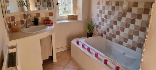 a bathroom with a tub and a sink at Domaine du Moulin de Cors in La Roque-sur-Cèze