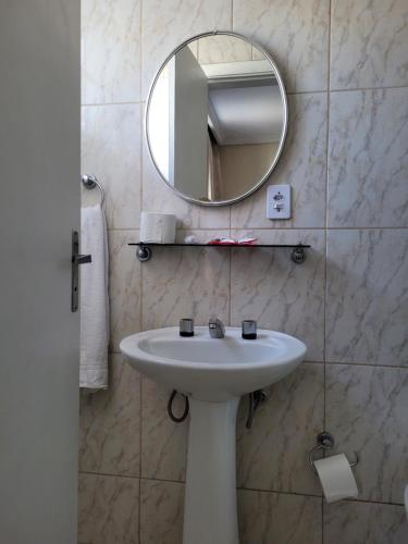 a bathroom with a white sink and a mirror at Hotel Estação Express in Curitiba