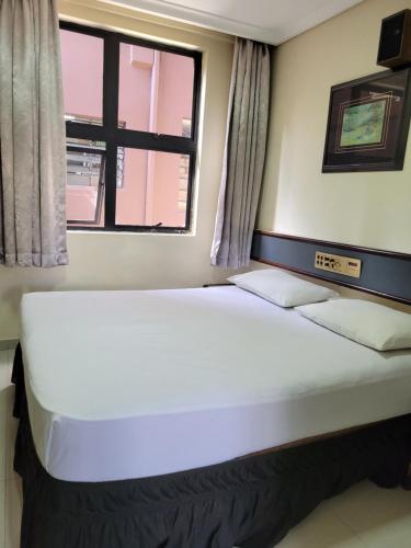 a large bed in a room with a window at Hotel Estação Express in Curitiba