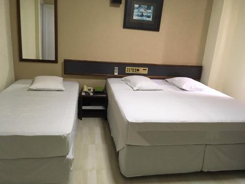 two beds in a hotel room with two beds sidx sidx sidx at Hotel Estação Express in Curitiba