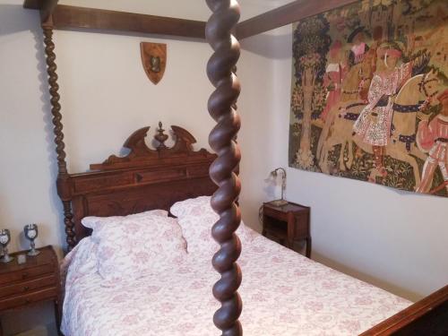 a bedroom with a wooden bed with a wooden post at Villa Normandy in Gagny