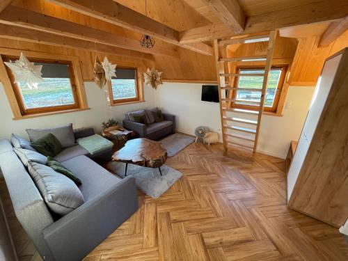 a living room with a couch and a staircase in a house at Smrekowe Zacisze in Bańska Niżna
