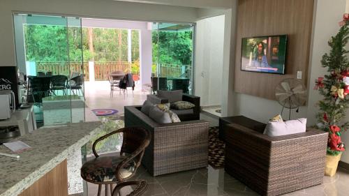 a living room with two chairs and a living room with a table at Sítio novo pousada in Piratuba