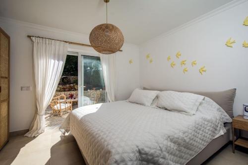 a white bedroom with a bed and a window at 401 Villa Salemar in Salema
