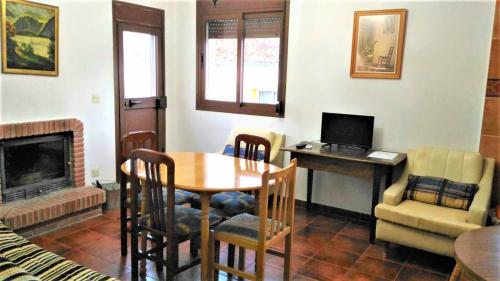 sala de estar con mesa y escritorio con ordenador portátil en Casa Rural El Sendero, en El Burgo