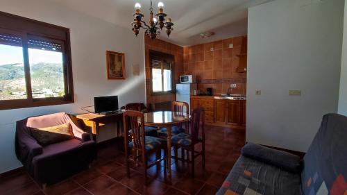 sala de estar con mesa y cocina en Casa Rural El Sendero, en El Burgo