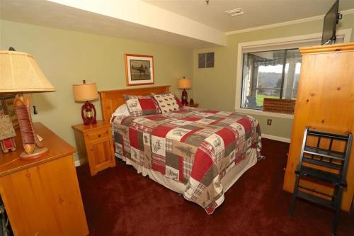 a bedroom with a bed and a desk and a window at Seven Springs 1 Bedroom Premium Condo, Ski In Ski Out condo in Champion