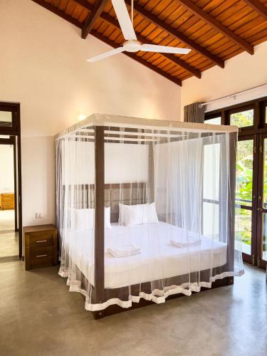 a bedroom with a canopy bed in a room at Villa Ema in Galle