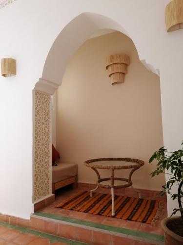 a room with a table and a bench in a room at DAR MAR'OUKA , Maison d'hôtes in Marrakech