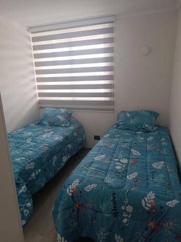 a bedroom with two twin beds and a window at DEPARTAMENTO EN LA SERENA in La Serena