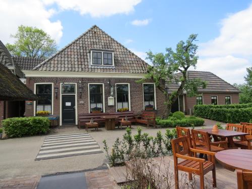 una casa con un patio con mesas y sillas en Hotel - Restaurant - Cafe- Geertien, en Blokzijl