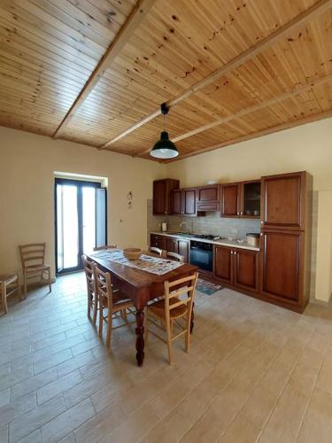 a large kitchen with a wooden table and chairs at La Casa di Argia in Bugnara