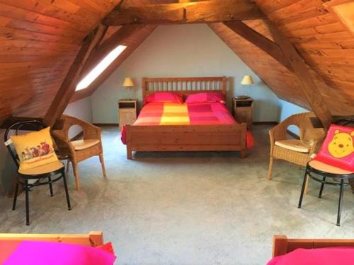 a bedroom with a bed and chairs in a attic at La Maison Tournesol - 3 bedroom house with large garden near Saumur in Saint-Martin-de-la-Place