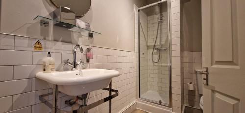 a bathroom with a sink and a shower at The Cross-Keys Hotel in Knutsford