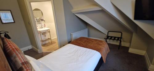 a small room with a bed and a sink at The Cross-Keys Hotel in Knutsford