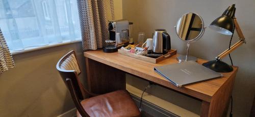 a desk with a laptop and a mirror on it at The Cross-Keys Hotel in Knutsford