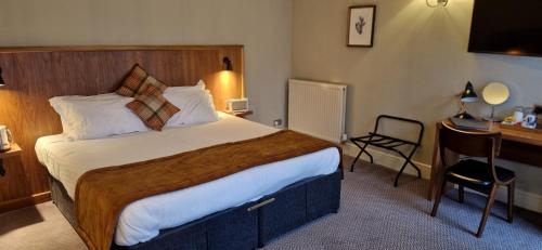 a hotel room with a bed and a desk at The Cross-Keys Hotel in Knutsford