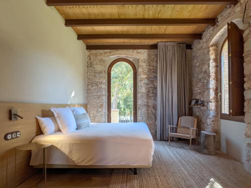 赫羅納的住宿－Torre de Can Puig，一间卧室设有一张大床和一个窗户。