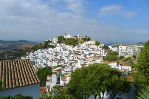 a group of white buildings on top of a hill at Ochomin Hostel in San Martín del tesorillo