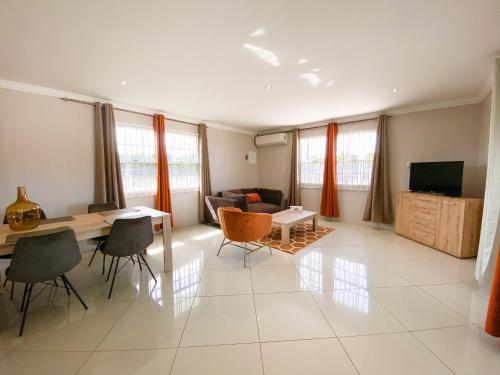 Benito Home في Tera Kora: غرفة معيشة مع طاولة وكراسي وأريكة