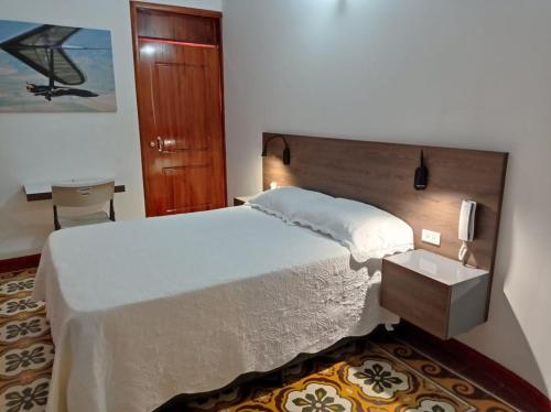 - une chambre avec un grand lit et une tête de lit en bois dans l'établissement Hotel Boutique el Sol, à Cartago