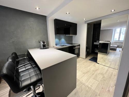 a kitchen with a counter and a bar stool at Appartement Design Centre ville in Saint-Tropez