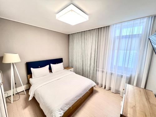 um quarto com uma cama e uma grande janela em The Trust Highvill Ishim D em Astana