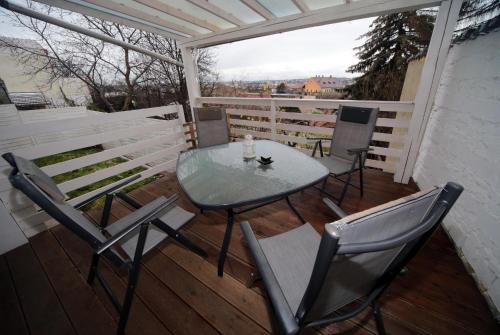 une table et des chaises en verre sur une terrasse avec vue dans l'établissement Étoile Apartman, à Eger
