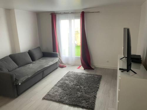 a living room with a couch and a television at Studio centre Ville in Antony