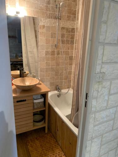 uma casa de banho com uma banheira e um lavatório e uma banheira em Charmant T2 La Foux d’Allos, 5 pers em Allos