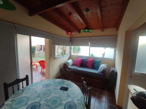 sala de estar con sofá y mesa en De paso primo camas simples cochera con rejas sin techo en Villa María