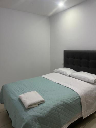 a white bedroom with a bed with a blue blanket at Apartamento en Ica 2 in Ica