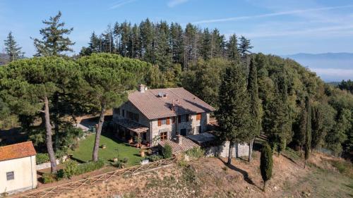 an aerial view of a house on a hill with trees at Montelucci Chianti Agrivilla in Gaiole in Chianti