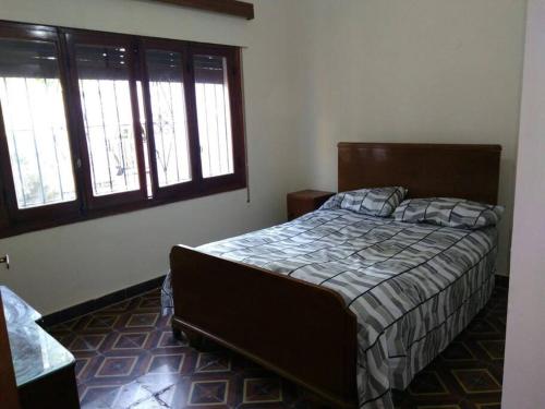 1 dormitorio con 1 cama y 2 ventanas en Casa Gattelli en San Rafael