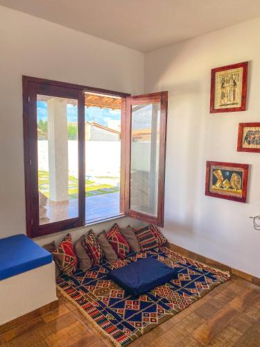 a room with a dog bed in front of a window at Casa Egípcia em Morro branco - na quadra da praia in Morro Branco