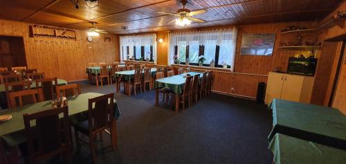 a dining room with tables and chairs in a restaurant at Pension Popelka in Špindlerův Mlýn