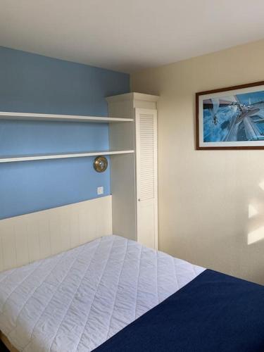 1 dormitorio con 1 cama y una pintura en la pared en Agréable T2 Lacanau Ocean bord de mer. Expo sud. en Lacanau-Océan