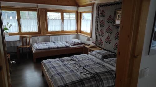 Zimmer mit 2 Betten in einem Zimmer mit Fenstern in der Unterkunft Dom u Mniszakow Agroturystyka in Witów