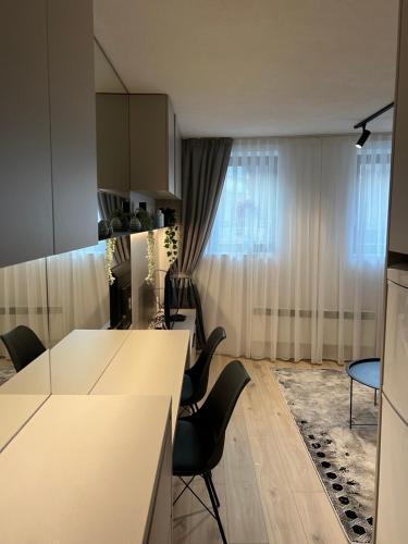 a kitchen with a white counter and chairs in a room at Old town,Kovaci 2 in Sarajevo