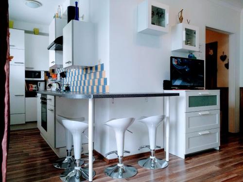 a kitchen with a counter and stools in it at Bomi Apartman in Győr